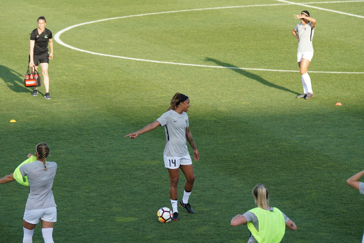 Team of female football players practising on a sports field.